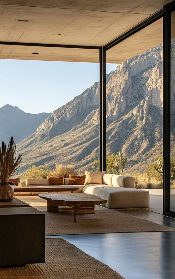 Open living room with floor-to-ceiling glass facing desert mountains